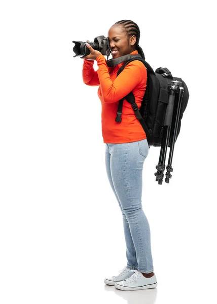 Mulher com câmera digital, tripé e mochila — Fotografia de Stock