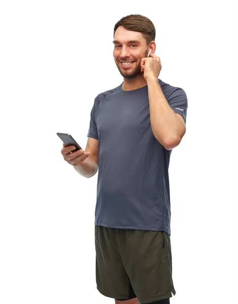 身穿运动服、手持电话和耳机的男人 — 图库照片