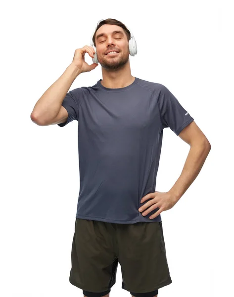 Χαμογελαστός άνδρας με αθλητικά ρούχα με ακουστικά — Φωτογραφία Αρχείου