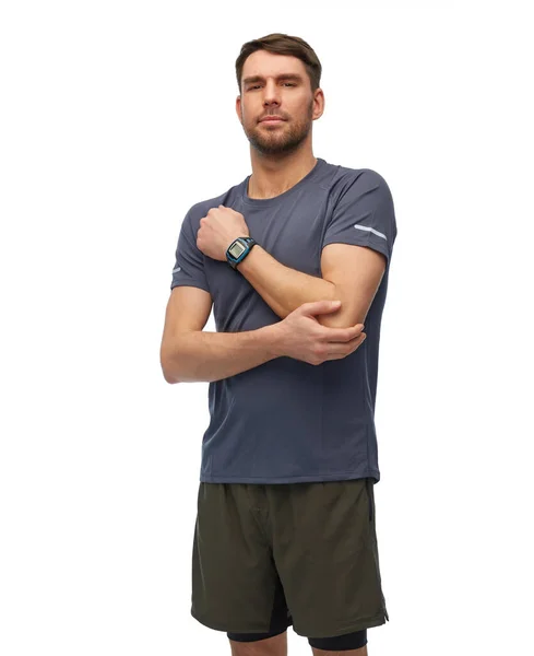 Man with fitness tracker holding to injured hand — Stock Photo, Image