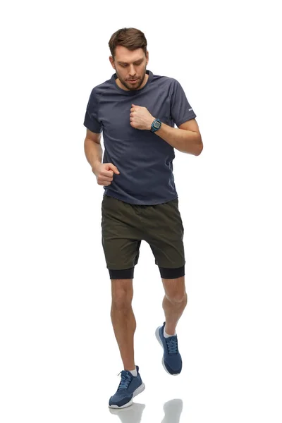 Hombre corriendo en ropa deportiva con reloj inteligente — Foto de Stock