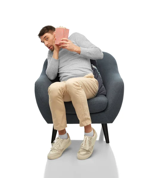 Hombre asustado con palomitas de maíz sentado en la silla — Foto de Stock