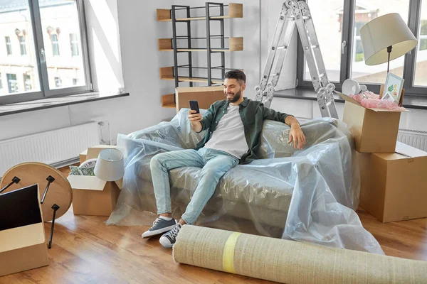 Mann mit Smartphone und Boxen zieht in neues Zuhause — Stockfoto