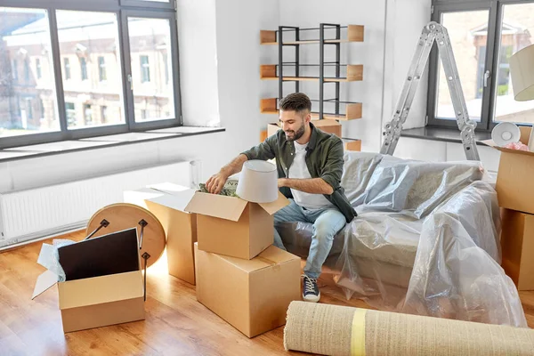 Hombre feliz desempacar cajas y mudarse a un nuevo hogar —  Fotos de Stock