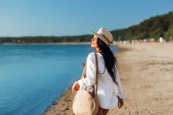 Mujer feliz con bolso caminando a lo largo de la playa de verano —  Fotos de Stock