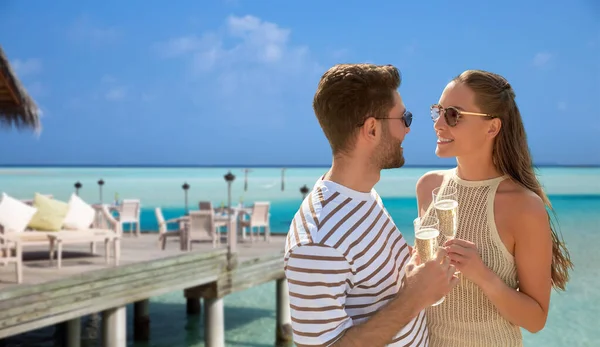 Šťastný pár se šampaňským nad plážovou restaurací — Stock fotografie