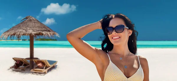 Sorridente giovane donna in occhiali da sole sulla spiaggia estiva — Foto Stock