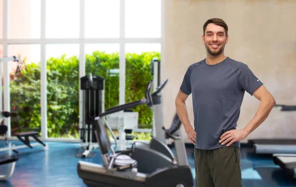 Sonriente hombre en ropa deportiva en el gimnasio — Foto de Stock