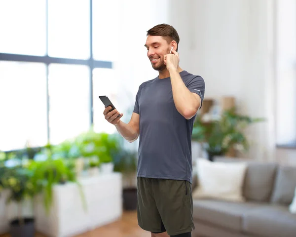Hombre en ropa deportiva con teléfono y auriculares — Foto de Stock