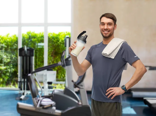 Hombre feliz con botella y toalla en el gimnasio — Foto de Stock