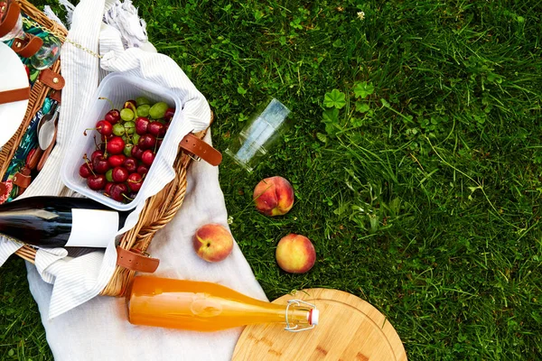 野餐毛毯上的食物、饮料和篮子 — 图库照片