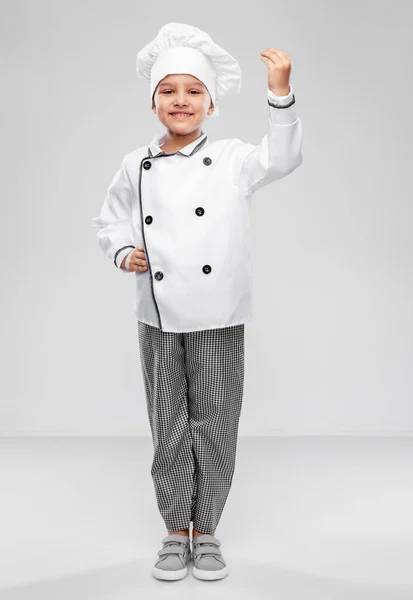 Mosolygós kislány szakácsok toque és kabát — Stock Fotó