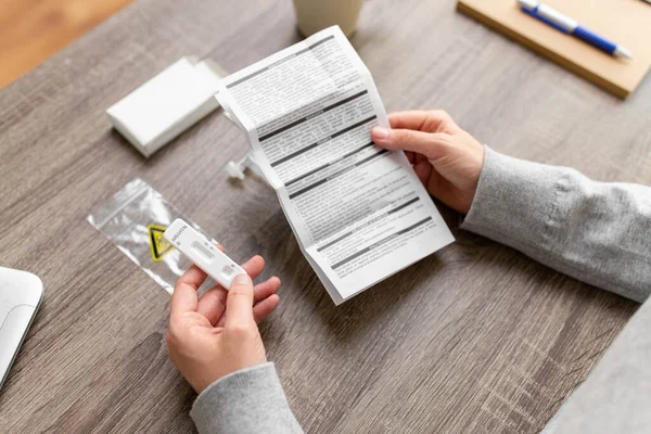 Femme lisant le manuel de test du coronavirus à la maison — Photo