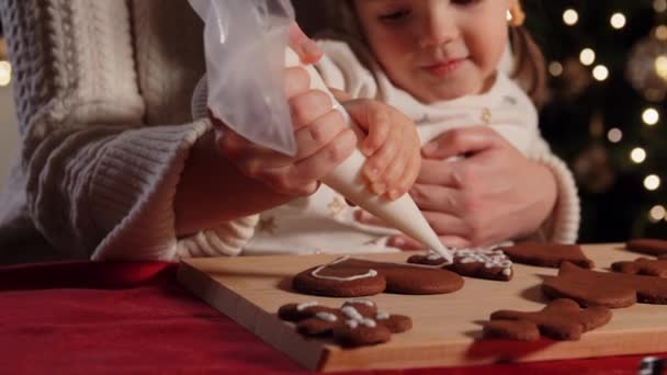 Madre e hija decorando pan de jengibre en casa — Vídeos de Stock