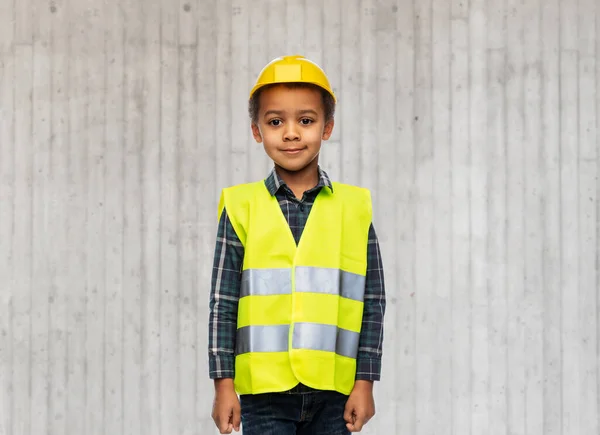 Menino em colete de segurança e capacete de construção — Fotografia de Stock