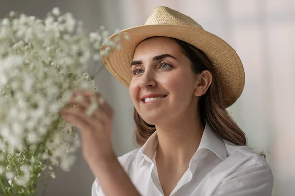 Mujer feliz sosteniendo flores de gypsophila en el estudio —  Fotos de Stock