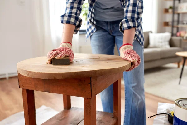 Frau schleift alten runden Holztisch mit Schwamm — Stockfoto