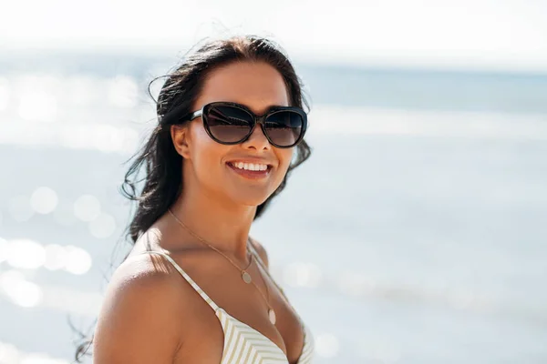 Glimlachende jonge vrouw in bikini badpak op het strand — Stockfoto