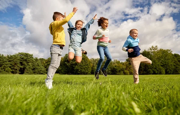 Glada barn hoppar i parken — Stockfoto