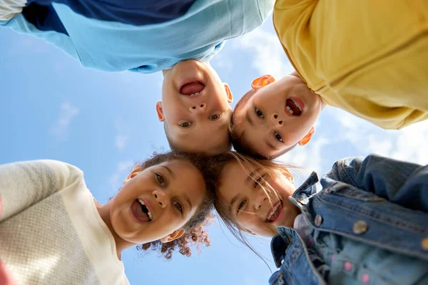 Grupo multiétnico de crianças felizes sob o céu azul — Fotografia de Stock