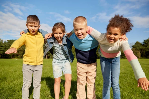 Группа счастливых детей, обнимающихся в парке — стоковое фото