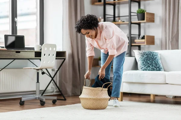 Femme heureuse avec couverture et panier en osier à la maison — Photo