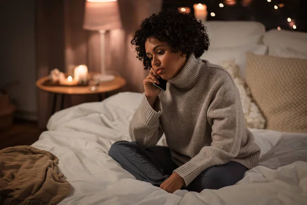 Kobieta dzwoni na smartfona w łóżku w domu — Zdjęcie stockowe