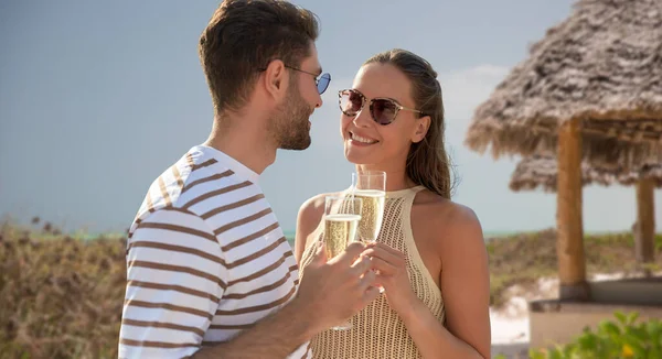 Mutlu çift yaz kumsalında şampanya içiyor. — Stok fotoğraf