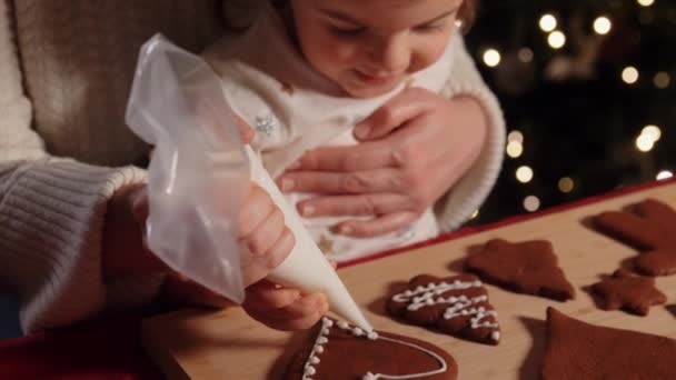 Madre e hija decorando pan de jengibre en casa — Vídeos de Stock