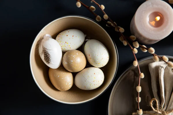 Påskägg, sälg och ljus på svart bord — Stockfoto