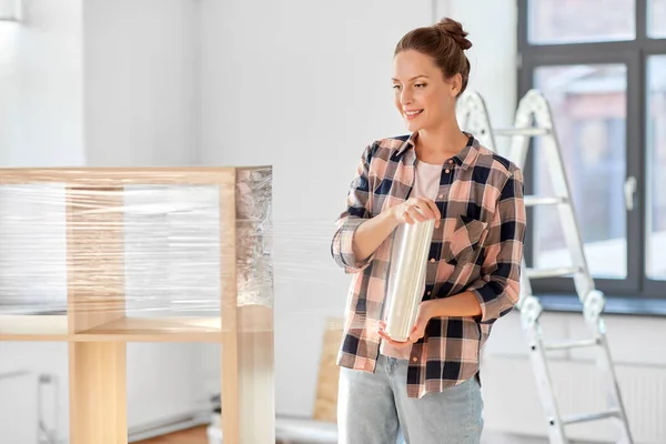 Happy woman packing shelf and moving to new home — Stock Photo, Image