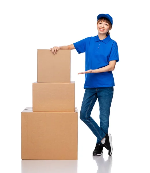 Kézbesítő nő kék egyenruhában csomagtartó dobozokkal — Stock Fotó