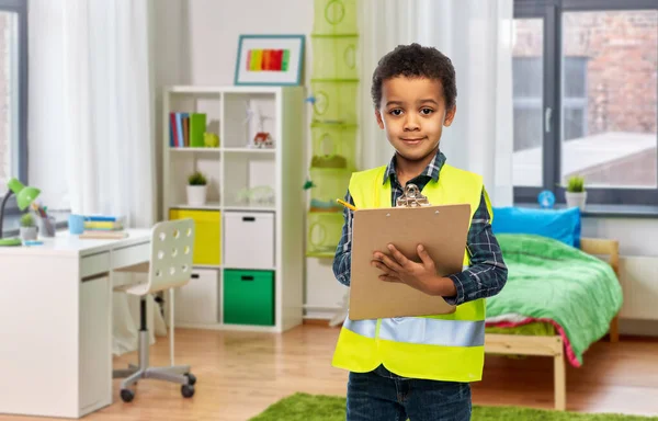 Little boy in safety vest with clipboard at home — Stock Photo, Image