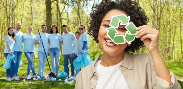 Femme heureuse regardant à travers signe de recyclage vert — Photo