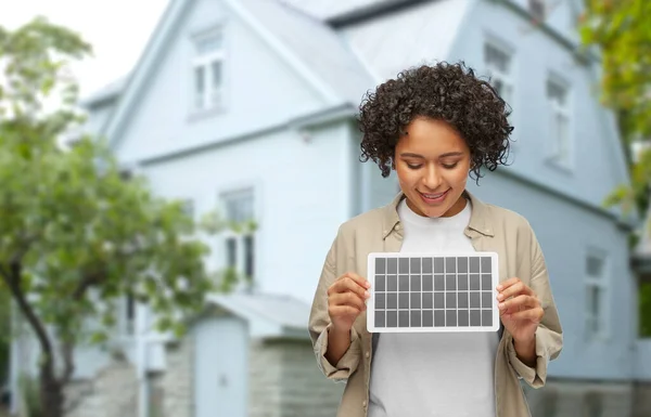 Donna sorridente con modello di batteria solare sopra la casa — Foto Stock