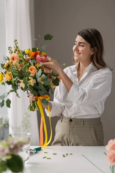 Boldog nő egy csomó virággal otthon — Stock Fotó