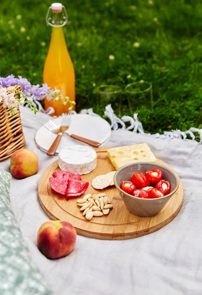 Nourriture, boissons et panier sur couverture de pique-nique sur herbe — Photo