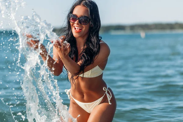 穿着比基尼泳衣的快乐的年轻女子在海滩上 — 图库照片