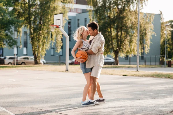 Glückliches Paar mit Ball auf Basketballplatz — Stockfoto