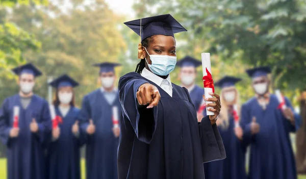 Kvinnlig doktorand i mask med diplom — Stockfoto