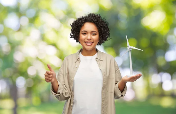 Mujer sosteniendo juguete aerogenerador mostrando pulgares hacia arriba — Foto de Stock