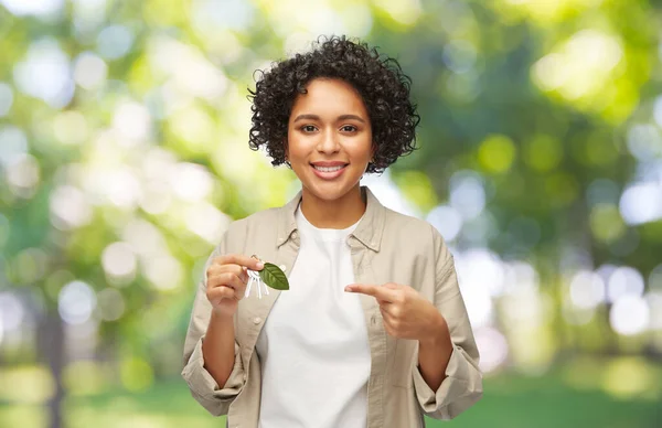 Femme tenant des clés de maison avec feuille verte — Photo