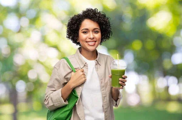 Mulher com saco de compras reutilizável beber smoothie — Fotografia de Stock