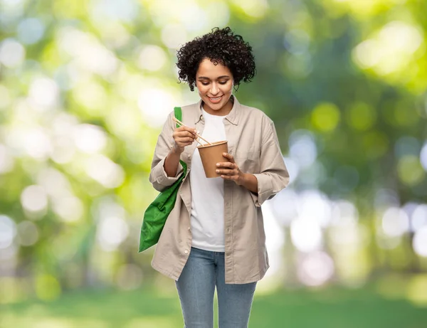 Woman with green reusable shopping bag and wok — Stock Photo, Image