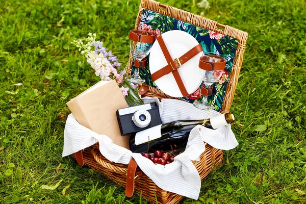 Suco, cereja, livro e câmera em cesta de piquenique — Fotografia de Stock