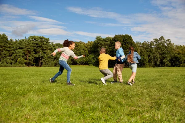Niños felices jugando y corriendo en el parque —  Fotos de Stock