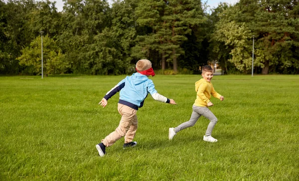 Glückliche Jungen spielen und rennen im Park — Stockfoto