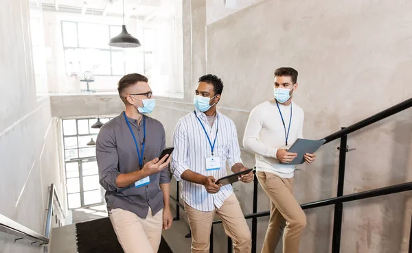 Hombres de negocios con máscaras con etiquetas que van arriba — Foto de Stock