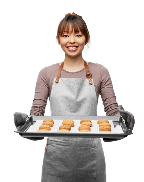 Heureux femelle dans tablier avec des cookies sur plateau de four — Photo