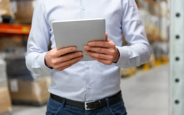 Empresário de feliz com o tablet pc no armazém — Fotografia de Stock